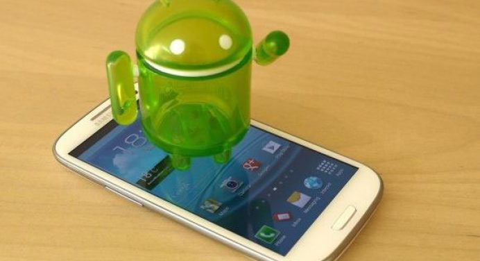 Android OS 5th Year - Samsung Phone With Android Tiny Mascot On Top - Droid Views
