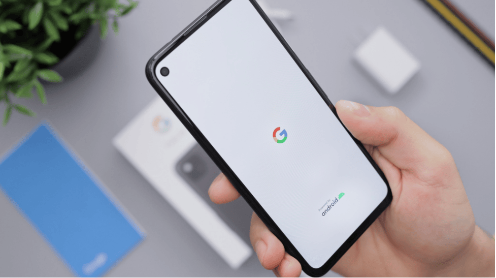 A hand holding an android phone with a Google logo