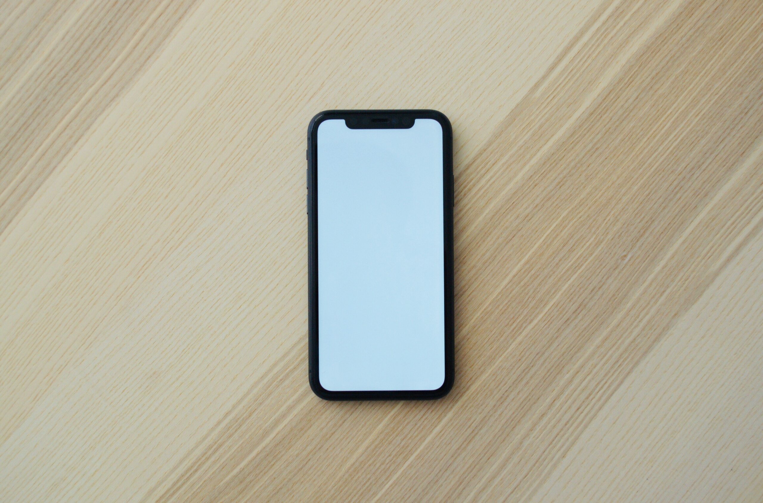 A picture of a mobile phone on a wooden background